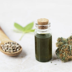 a glass of green liquid with a plant next to it